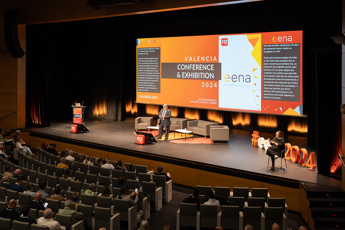 Eena2024-seminaarin auditorio, lavalla kaksi henkilöä ja taustalla iso näyttö.
