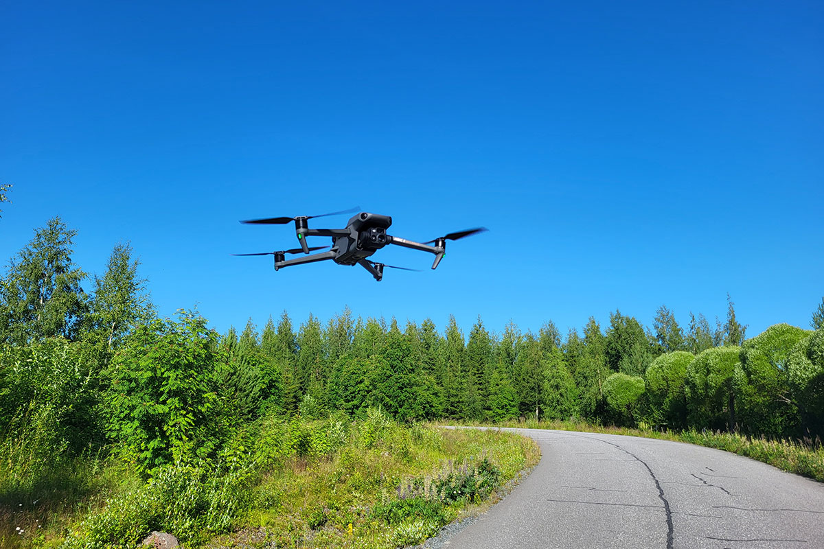 Dronea lennätetään pienen asfalttitien yläpuolella.