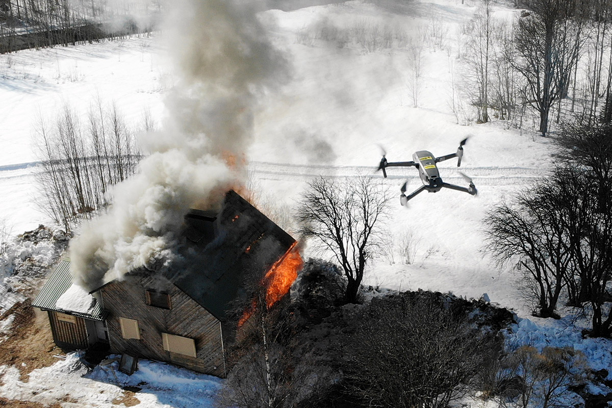 Drone lentää palavan rakennuksen yllä.