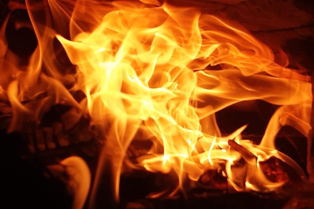 Keltaiset lieskat hehkuvat leivinuunin suulta.