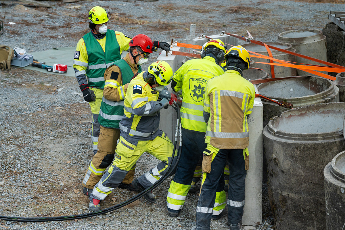 Keltaisissa työvaatteissa olevat pelastajat harjoittelevat betonin läpäisyä.