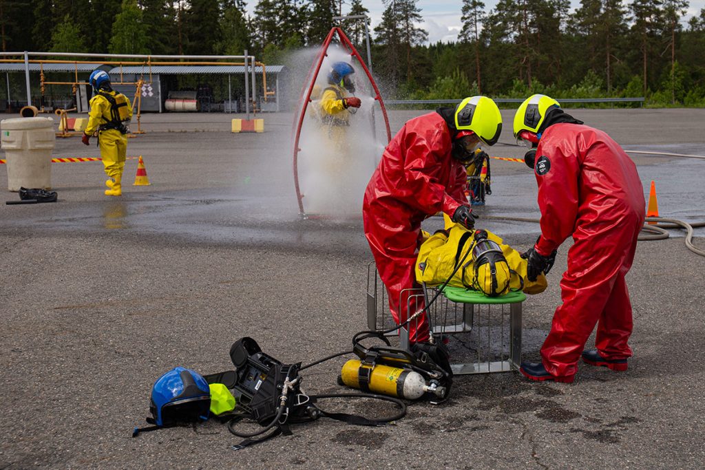 Neljä suoja-asuista henkilöä vaarallisten aineiden harjoituksessa.