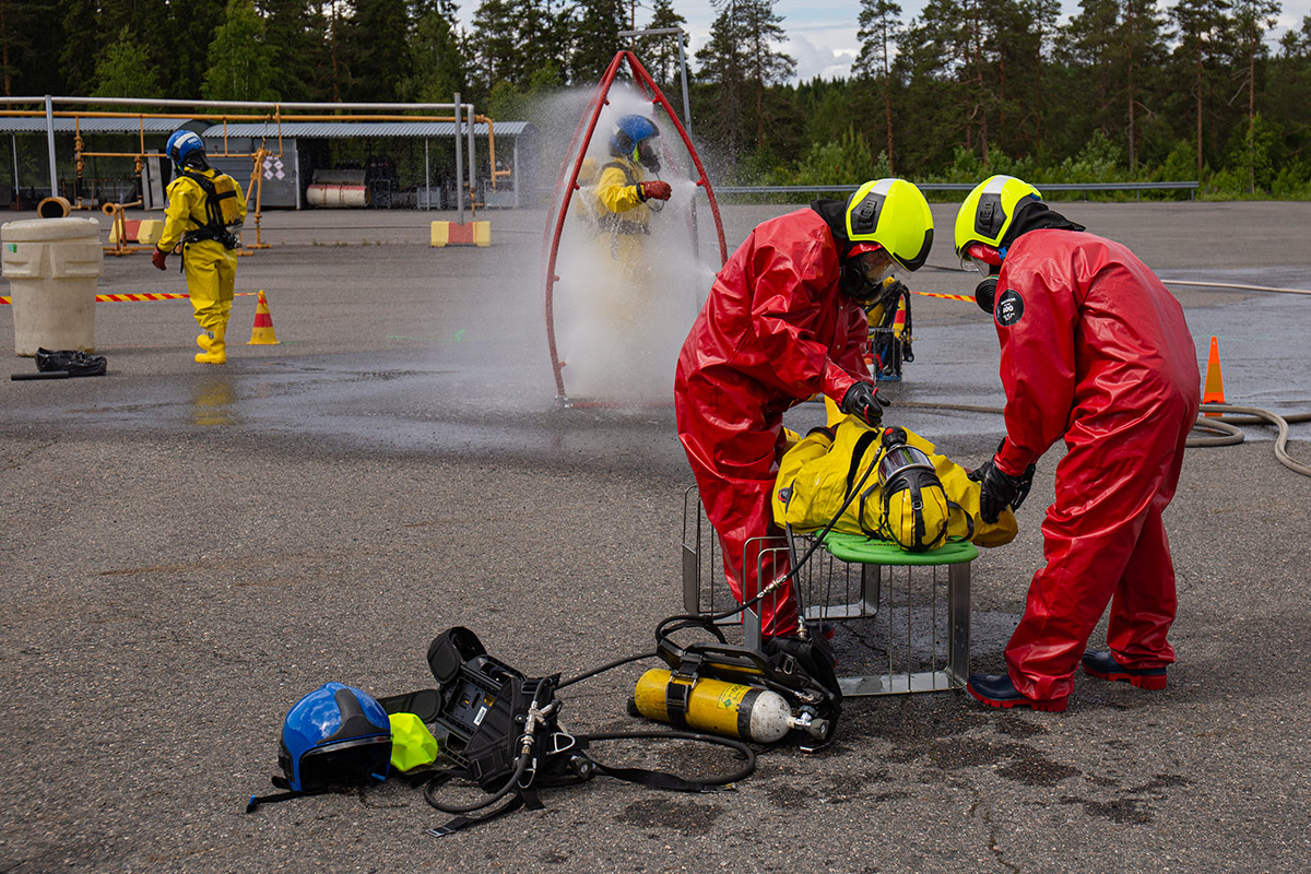 Neljä suoja-asuista henkilöä vaarallisten aineiden harjoituksessa.