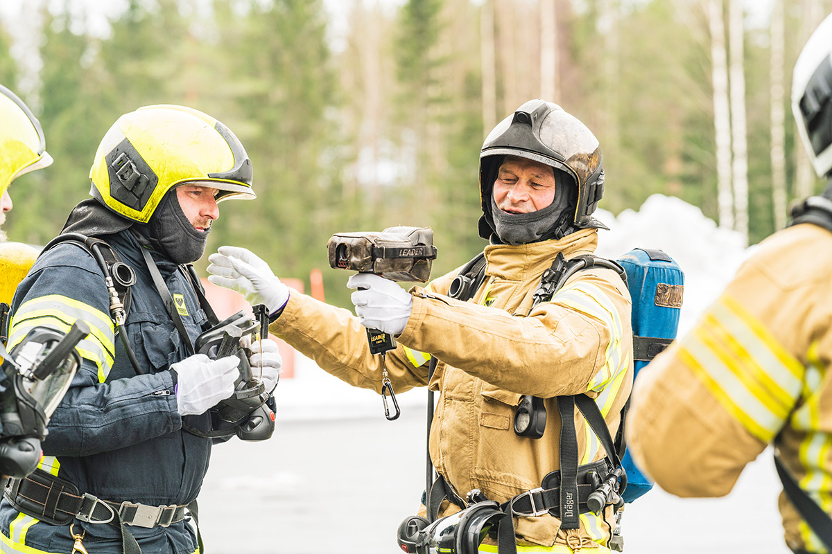 Kouluttaja ohjaa henkilöitä sammutustekniikkakurssilla.