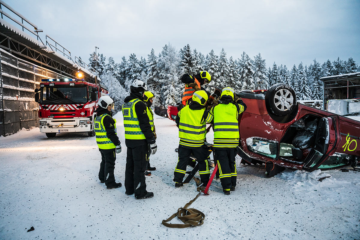 Henkilöitä avaamassa katollaan olevaa autoa.
