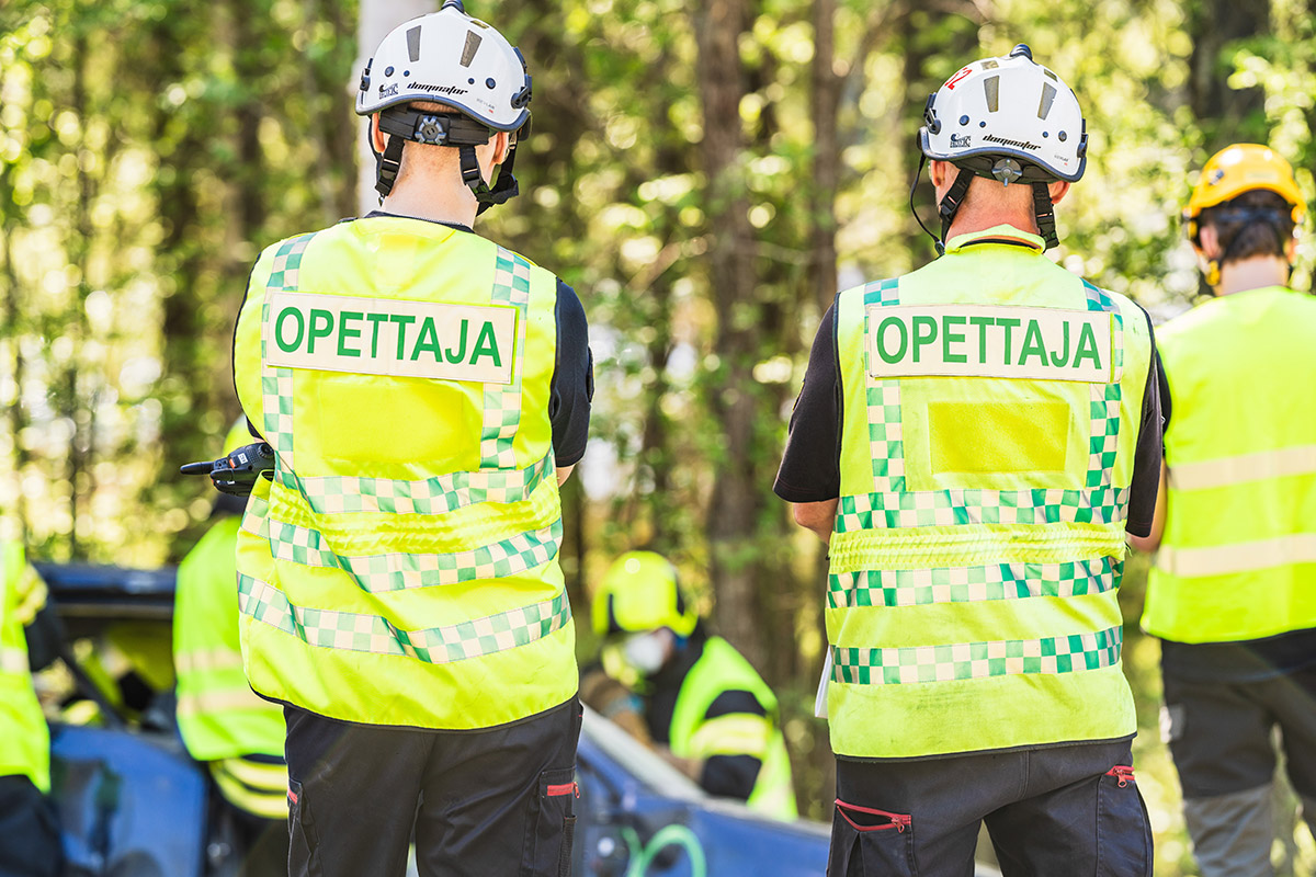 Kaksi opettajaa seuraamassa liikenneonnettomuusharjoitusta.