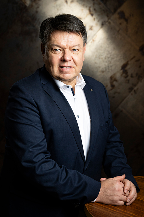 Puolivartalokuva henkilöstä, joka hymyilee ja katsoo kameraan.