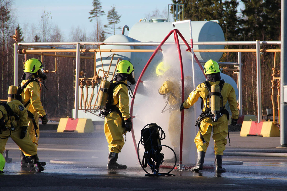 Viisi suojapukuista henkilöä kemikaalisukelluskurssilla.