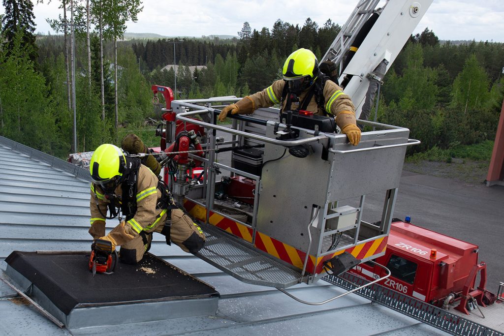 Pelastushenkilöstöä talon katolla.