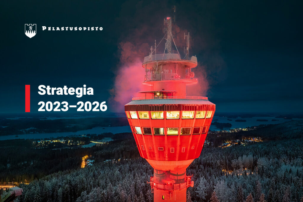 Liekehtivä Puijon torni tummaa maisemaa vasten. Pelastusopiston logo sekä teksti strategia 2023-2026.
