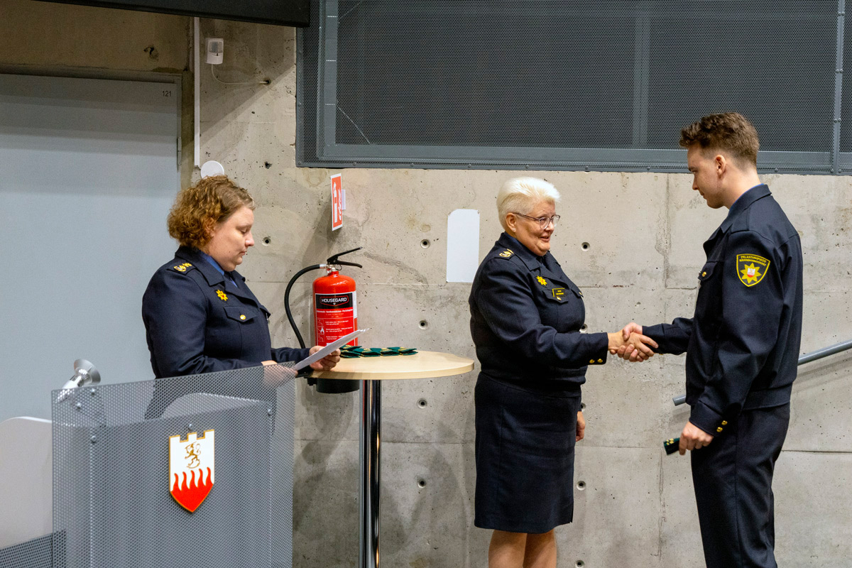 Rehtori kättelee opiskelijaa.
