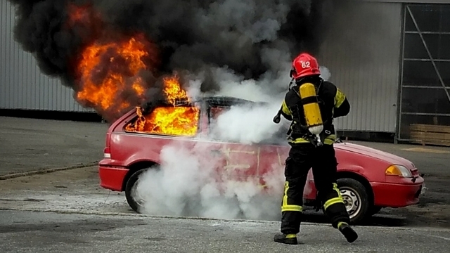 Palomies sammuttaa autopaloa.