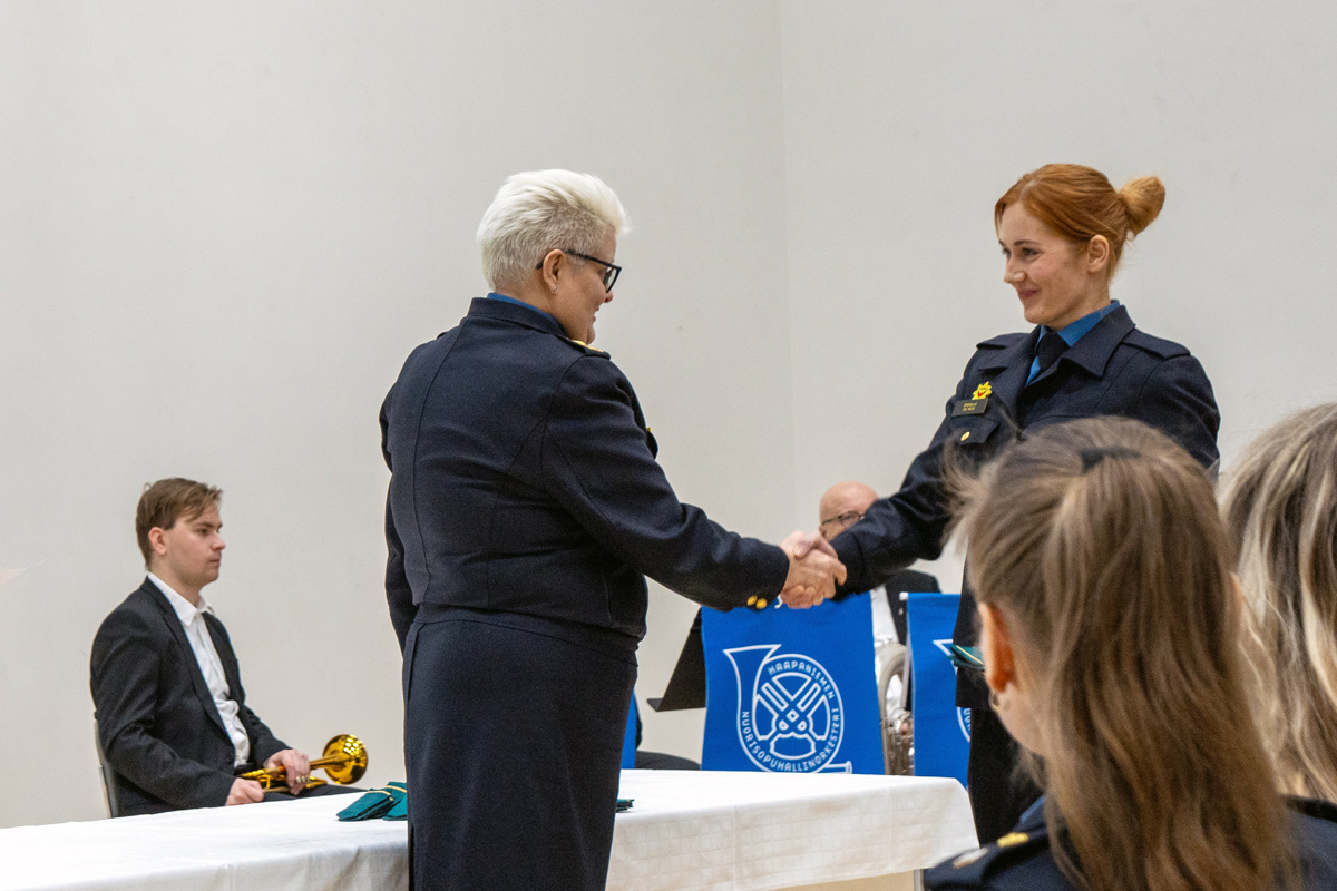 Rehtori kättelee opintonsa aloittavaa pelastajaopiskelijaa.