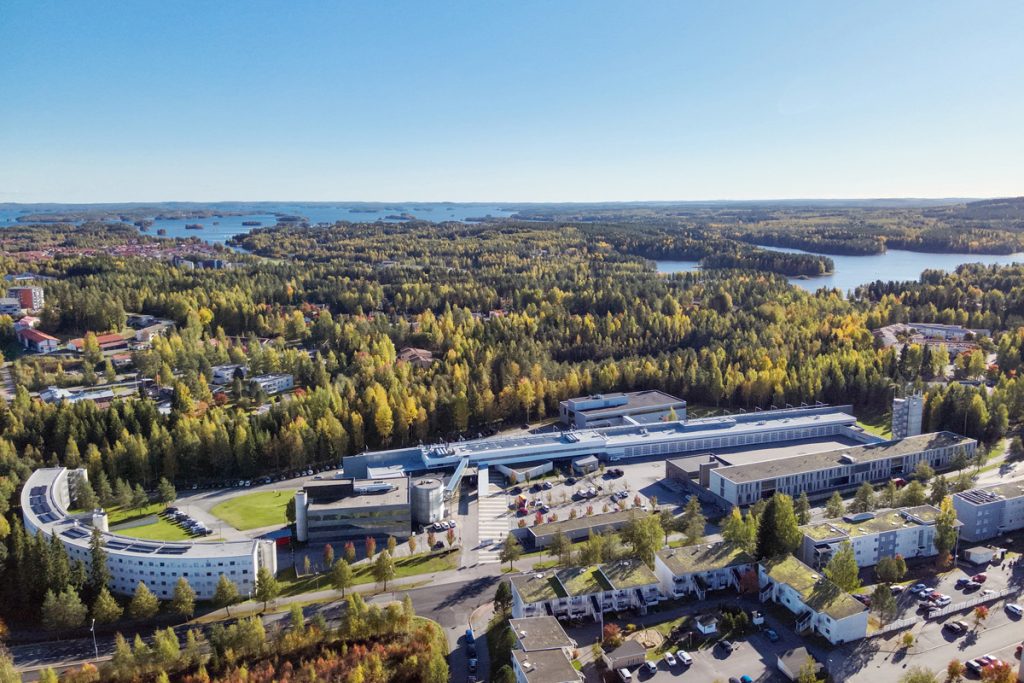 Pelastusopiston kampusalue ilmasta kuvattuna. Taustalla näkyy asuinaluetta, metsää ja järviä.