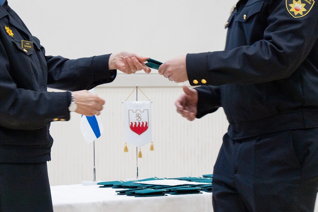 Rehtori ojentaa aloittavalle opiskelijalle opiskelijatunnukset.