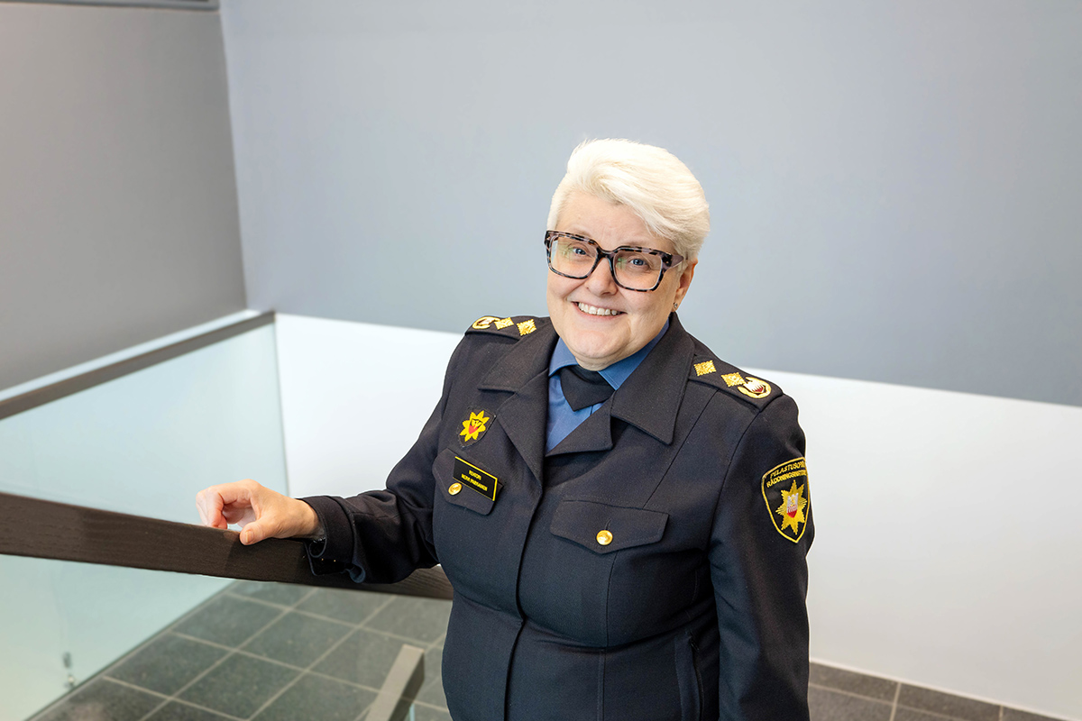 Henkilö seisoo rappusissa ja katsoo hymyillen kameraan.
