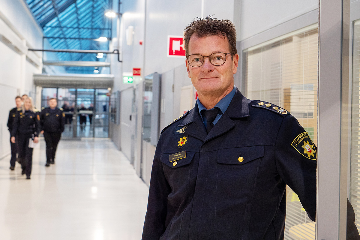 Yliopettaja Matti Honkanen Pelastusopiston käytävällä, opiskelijoita taustalla.