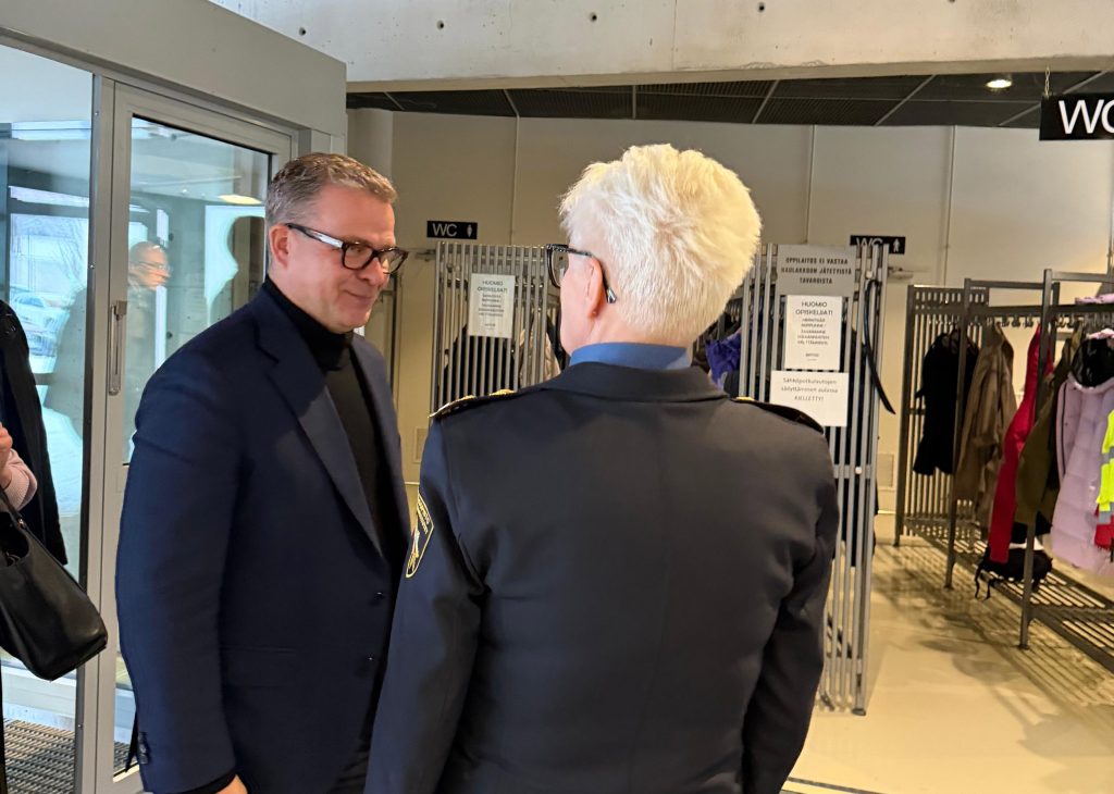 Pääministeri Petteri Orpo ja rehtori Mervi Parviainen kättelevät Pelastusopiston aulassa.