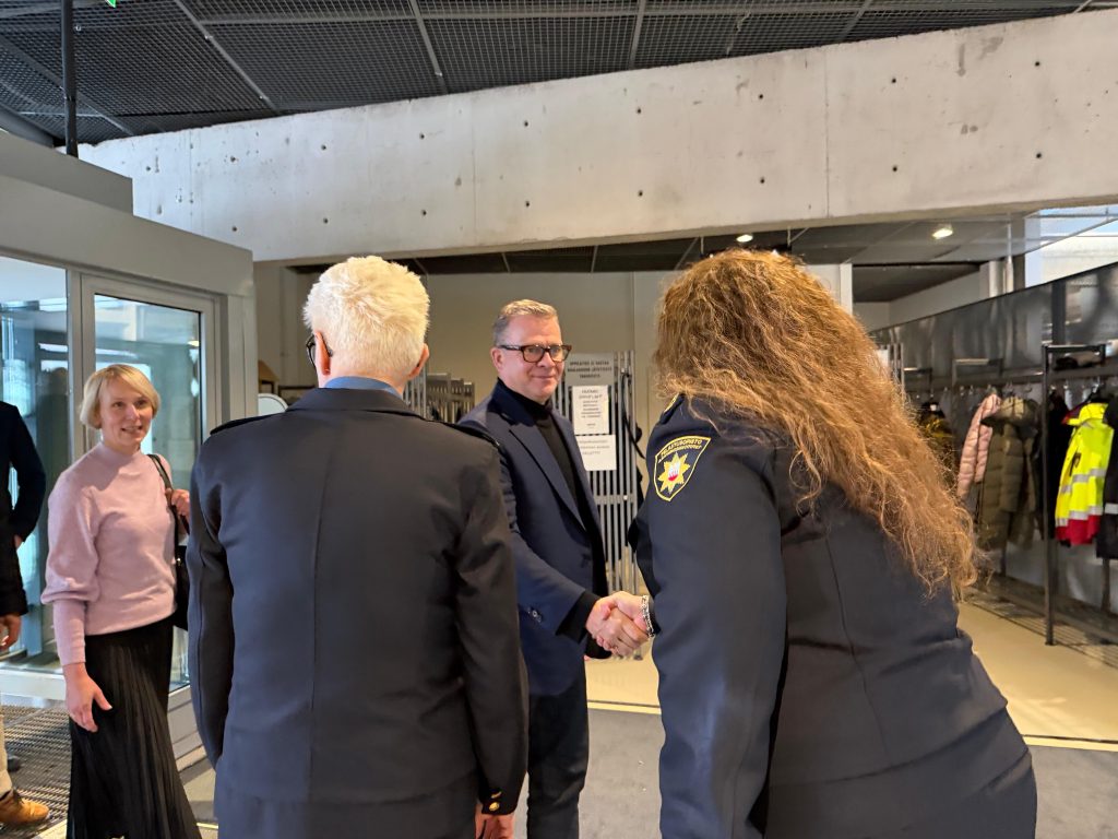 Pääministeri Petteri Orpo ja koulutusjohtaja Minna Hirvonen kättelevät Pelastusopiston aulassa.