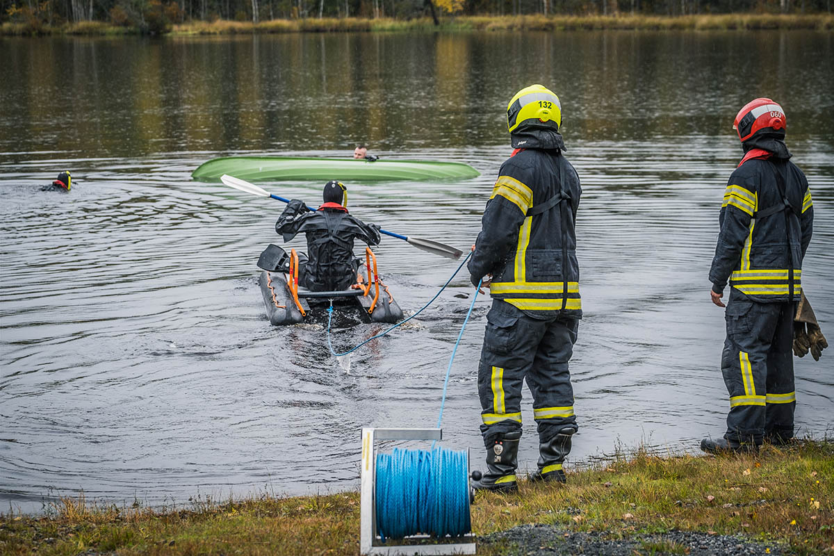 Henkilö soutaa veden varaan joutuneen henkilön luokse pintapelastusharjoituksessa.