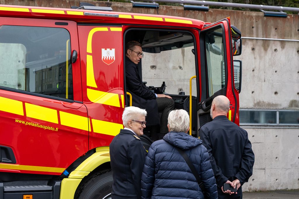 Tasavallan presidentti istuu sammutusautossa Pelastusopiston sisäpihalla.