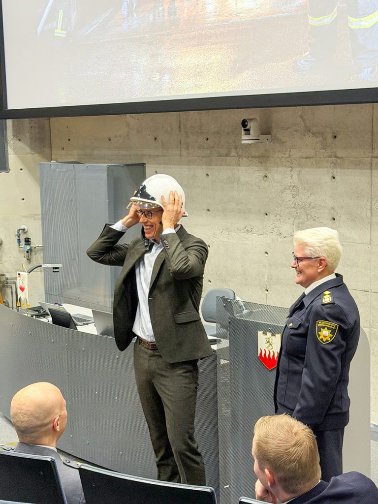 Tasavallan presidentti sovittaa saamaansa priimuskypärää auditoriossa.