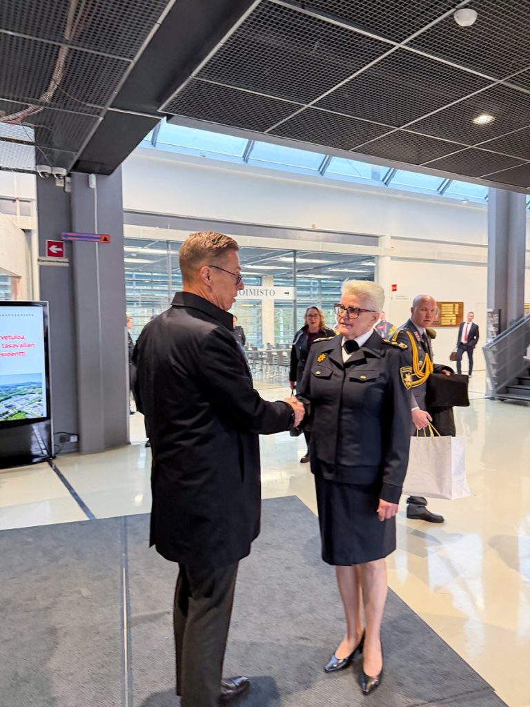 Tasavallan presidentti ja Pelastusopiston rehtori kättelevät Pelastusopiston pääaulassa vierailun päätteeksi.