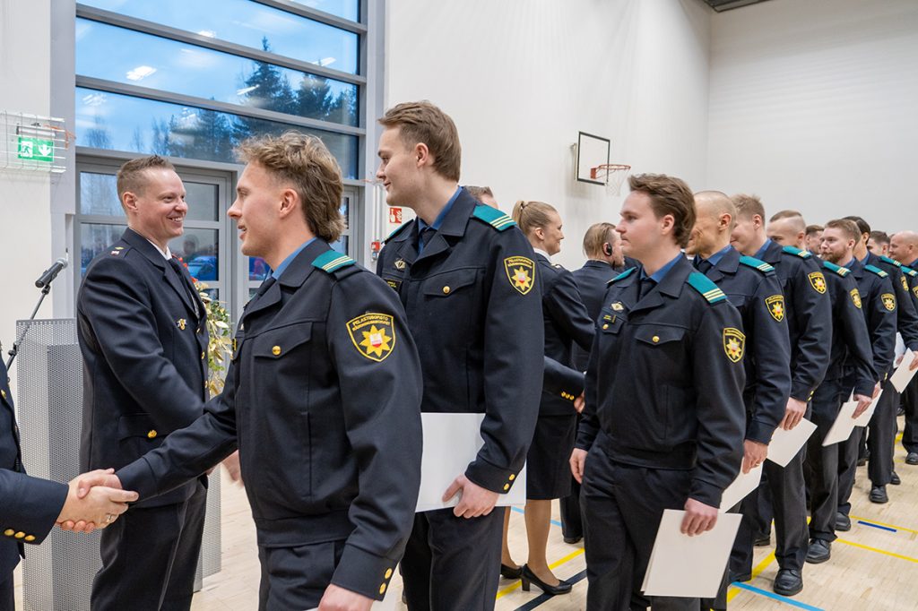 Valmistuneet opiskelijat kättelevät opettajia.