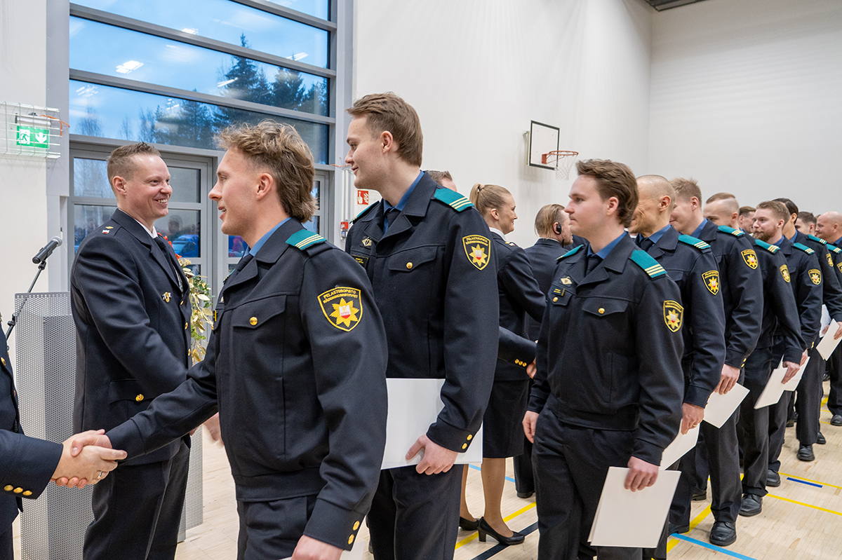 Valmistuneet opiskelijat kättelevät opettajia.